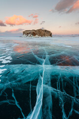 Early morning on the ice of lake Baikal against the background of mountains and ice