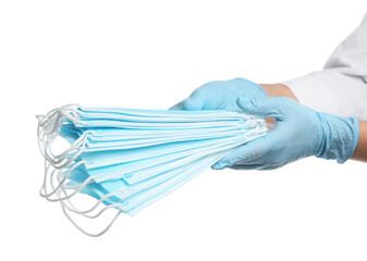 Doctor in latex gloves holding disposable face masks on white background, closeup. Protective measures during coronavirus quarantine