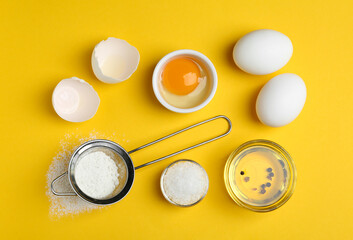 Flat lay composition with chicken eggs on yellow background