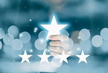 Hand holding star symbol give five stars rating. Reviews and Evaluation concept.