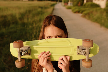 11 year old girl in shorts skateboarding at sunset on the street.