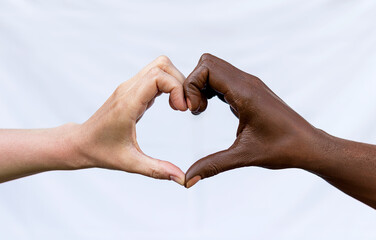 Two hands with black and white skin in the shape of a heart symbolize the fight against racism....