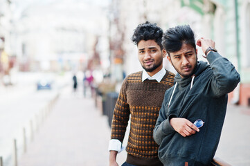 Two young stylish indian man frieds model posing in street.