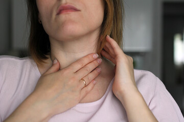 hand clutching the neck with a sore throat, close-up