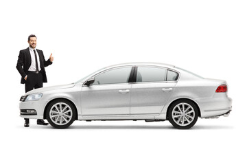 Businessman standing next to a silver car and showing thumbs up