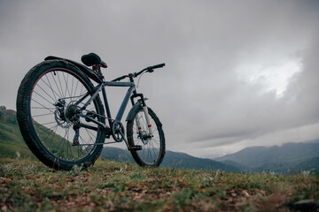 Fototapeta na wymiar Грязный горный велосипед на вершине горы с восхитительным видом . 