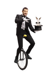 Magician on a unicycle and performing a magic trick with a hat and a rabbit © Ljupco Smokovski