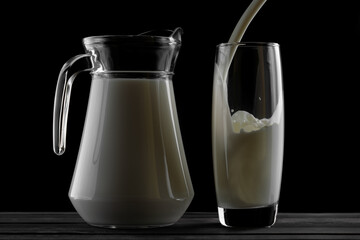 jug of milk and a glass on a black background