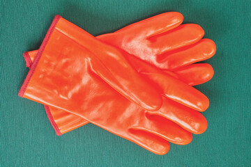 Orange work gloves with chemical protection.