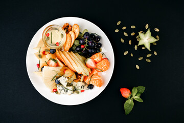 healthy tasty food on a white plate lies on a black background.