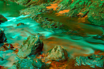 Stones in a stream with water blurred by long exposure

