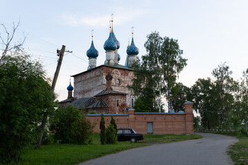 Country landscape in summer evening with vintage car and old cherch