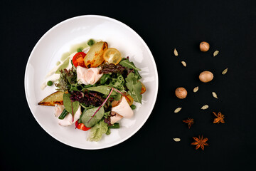 healthy tasty food on a white plate lies on a black background.