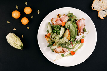 healthy tasty food on a white plate lies on a black background.