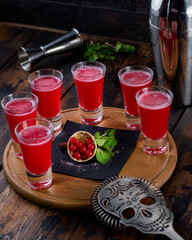 alcohol shot cocktails with skull lies on wood background