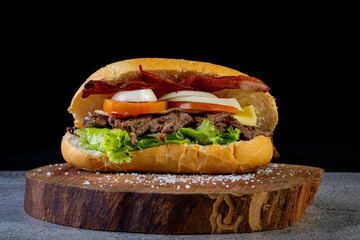 Big homemade sandwich with beef, lettuce, tomato, onion and cheese. Brazilian style