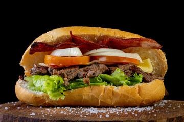 Big homemade sandwich with beef, lettuce, tomato, onion and cheese. Brazilian style