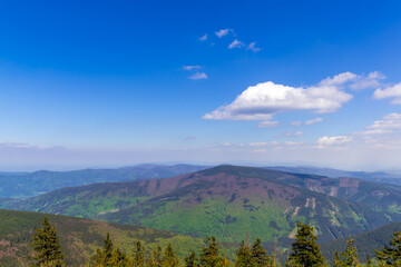 Mountainous landscape and views of the hills during a sunny day with clouds in the sky.