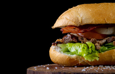Big homemade sandwich with beef, lettuce, tomato, onion and cheese. Brazilian style