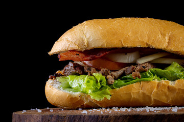 Big homemade sandwich with beef, lettuce, tomato, onion and cheese. Brazilian style