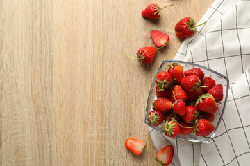 Bowl with tasty strawberry on wooden table. Summer berry