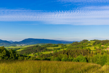 View of nature surrounded by forest and in the sky full of clouds with a view of the mountain landscape around the Beskydy Mountains.