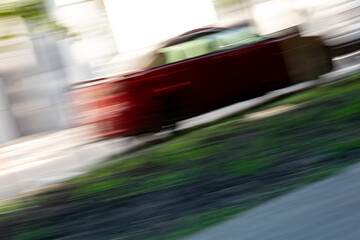 Fototapeta premium Abstract photo of a fast-moving red car.