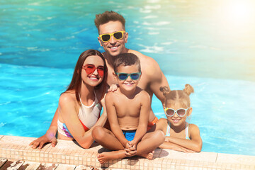 Happy family in swimming pool on sunny day