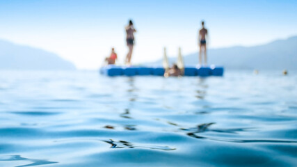 Blurred image of young people relaxing on pontoon in the sea © Kyrylo Ryzhov