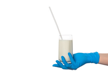 hand in a protective glove holds a glass with milk and a straw on a white background