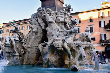 Fototapeta na wymiar Fountain of the Four Rivers on Piazza Navona. Ancient fountain, statues, obelisk design of Bernini. Famous landmark touristic location near Sant Agnese in Agone church in Rome, Italy