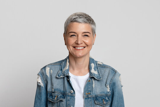 Sincere Happiness. Portrait of positive middle-aged woman laughing over light studio background