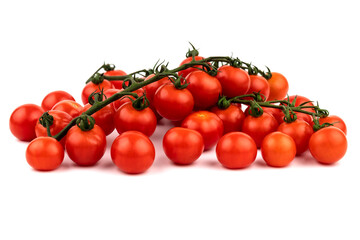 Cherry tomatoes on a green branch next to individual cherry tomatoes.