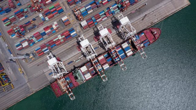 Time lapse Container ship in export and import business and logistics. Shipping cargo to harbor by crane. Water transport International. Aerial view and top view.