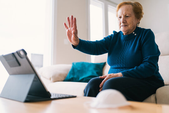 Senior woman communicating with friend during video chat on laptop