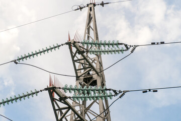 high-voltage lines close-up against the sky with clouds