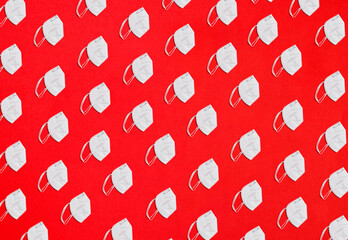 Collage of many KN95 factor protection masks on a red background overhead view in diagonal distribution