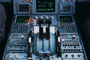 From above of engine power control levers and switches on instrument panel inside contemporary civil passenger airplane