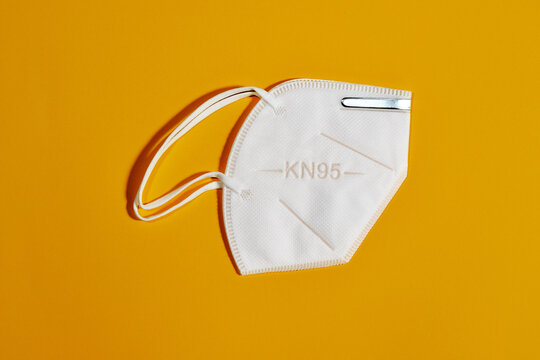 White mask with reusable KN95 protection index for virus protection on yellow background
