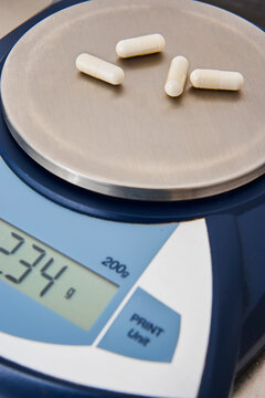 Weighing of capsules and pills in precision scales of medicine and liquid pharmaceutical products in laboratory