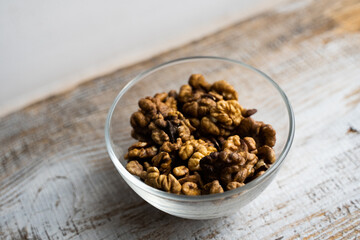 Walnut in a small plate on a vintage wooden table. Walnuts is a healthy vegetarian protein nutritious food. Natural nuts snacks.