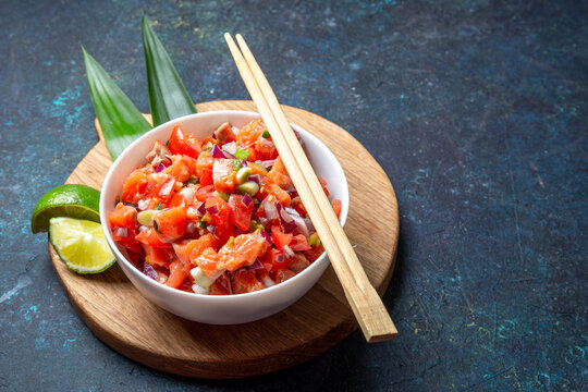 Fototapeta Lomi lomi salmon, hawaiian raw salmon salad on blue background