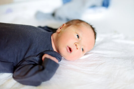 Cute little newborn baby boy lying on a changing table. Portrait of tiny new baby at home.