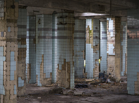 Concrete walls and remains of stairways in old abandoned industrial building with messy ground