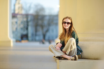 Cute young girl sightseeing on the streets of Vilnius, Lithuania on warm and sunny spring day.