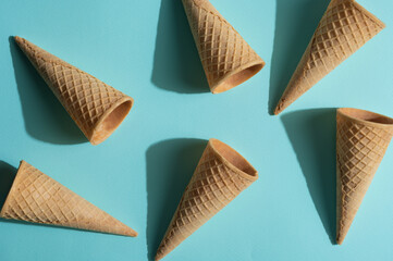 A lot of waffle cones for ice cream on a blue background, creative photo