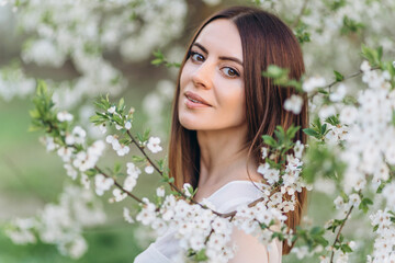 Amazing young woman posing in Blooming tree orchard at spring