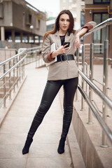 Beautiful young girl in a business suit on a background of business center. Business theme