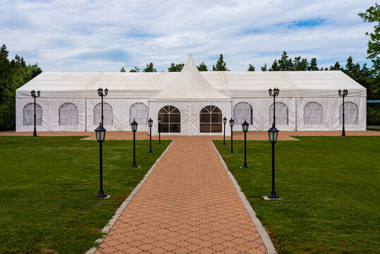 White tent for weddings and celebrations with trees in the background