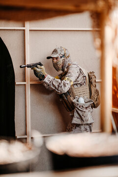 Soldier aiming airsoft gun during tactical game